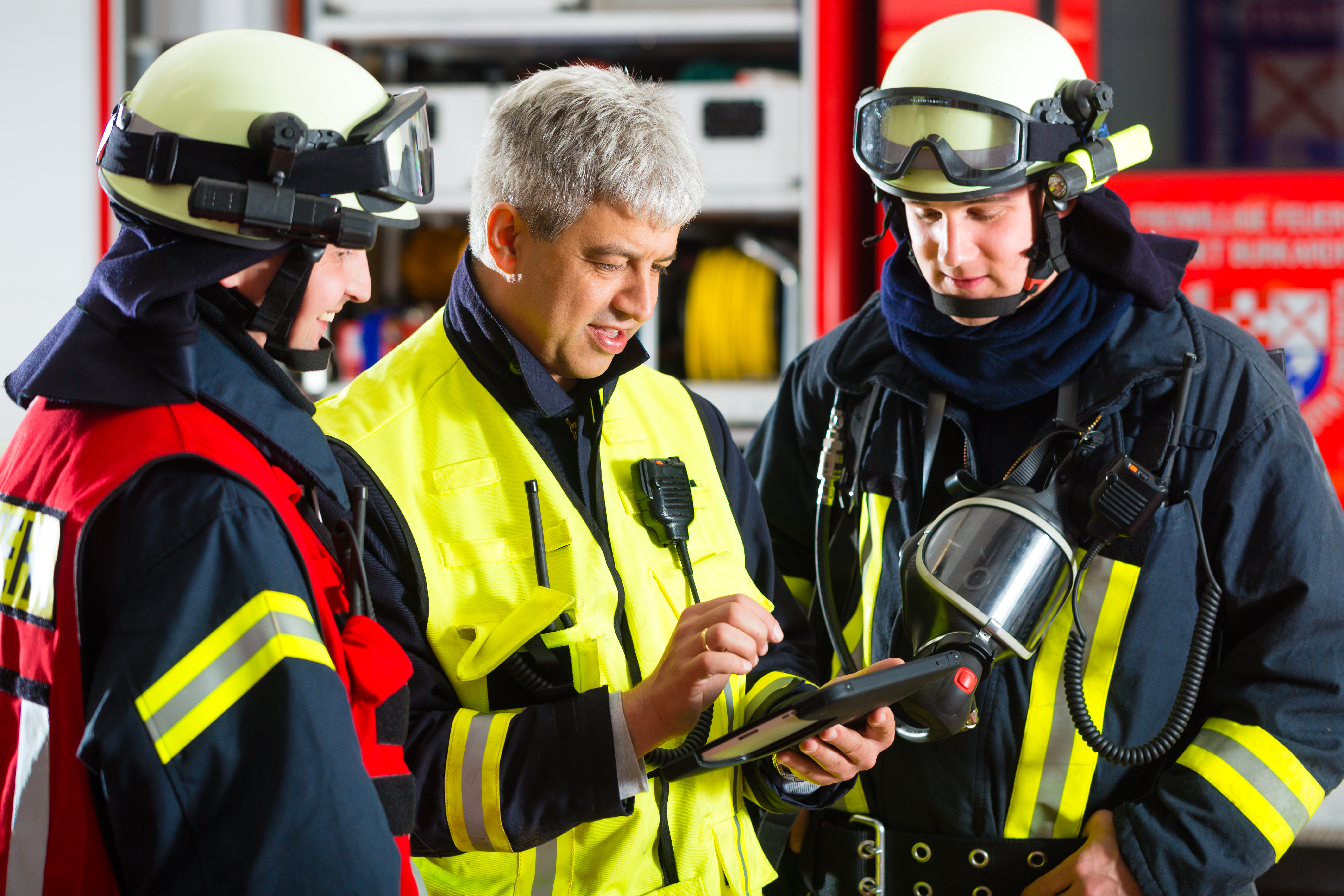 Pompiers regardant une tablette gérée et sécurisée par SOTI ONE Platform